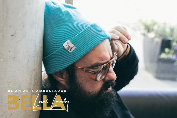 A bearded man wearing glasses and a blue toque, exuding a casual and stylish appearance.