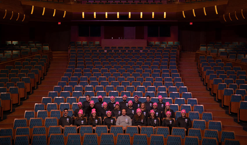 People in the Bella Concert Hall wearing centre the arts sweaters and toques.